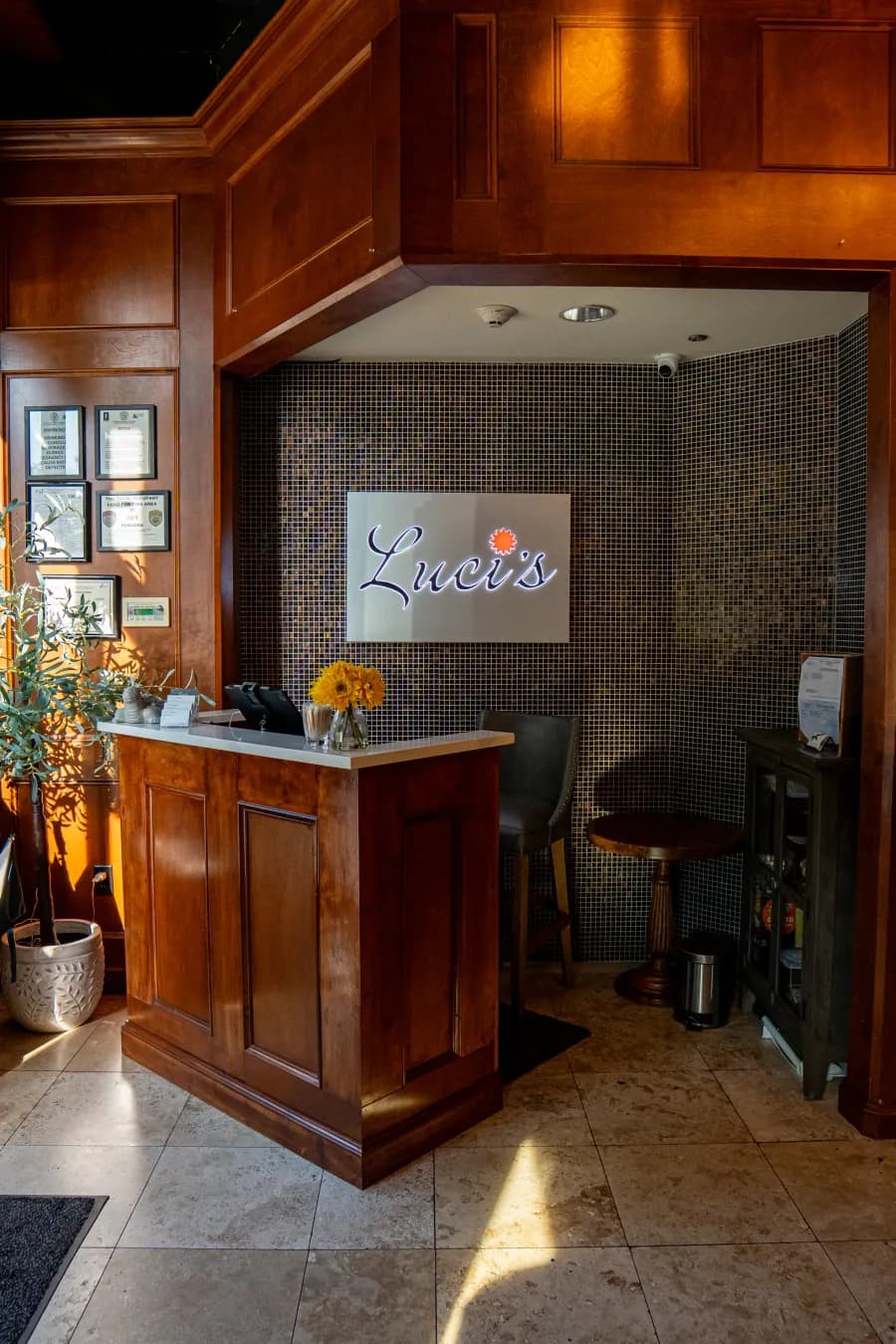 The host stand at the entrance of Luci's, under the house sign